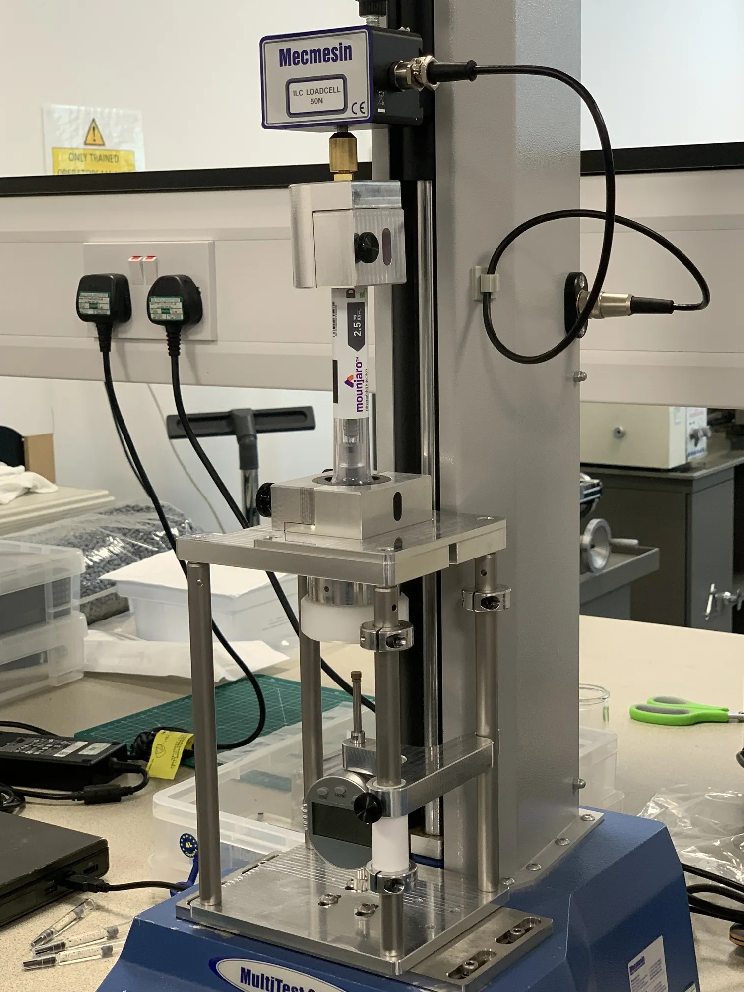 Custom modular test rig on the Mecmesin force machine, angled view - autoinjector characterisation in clean bio lab